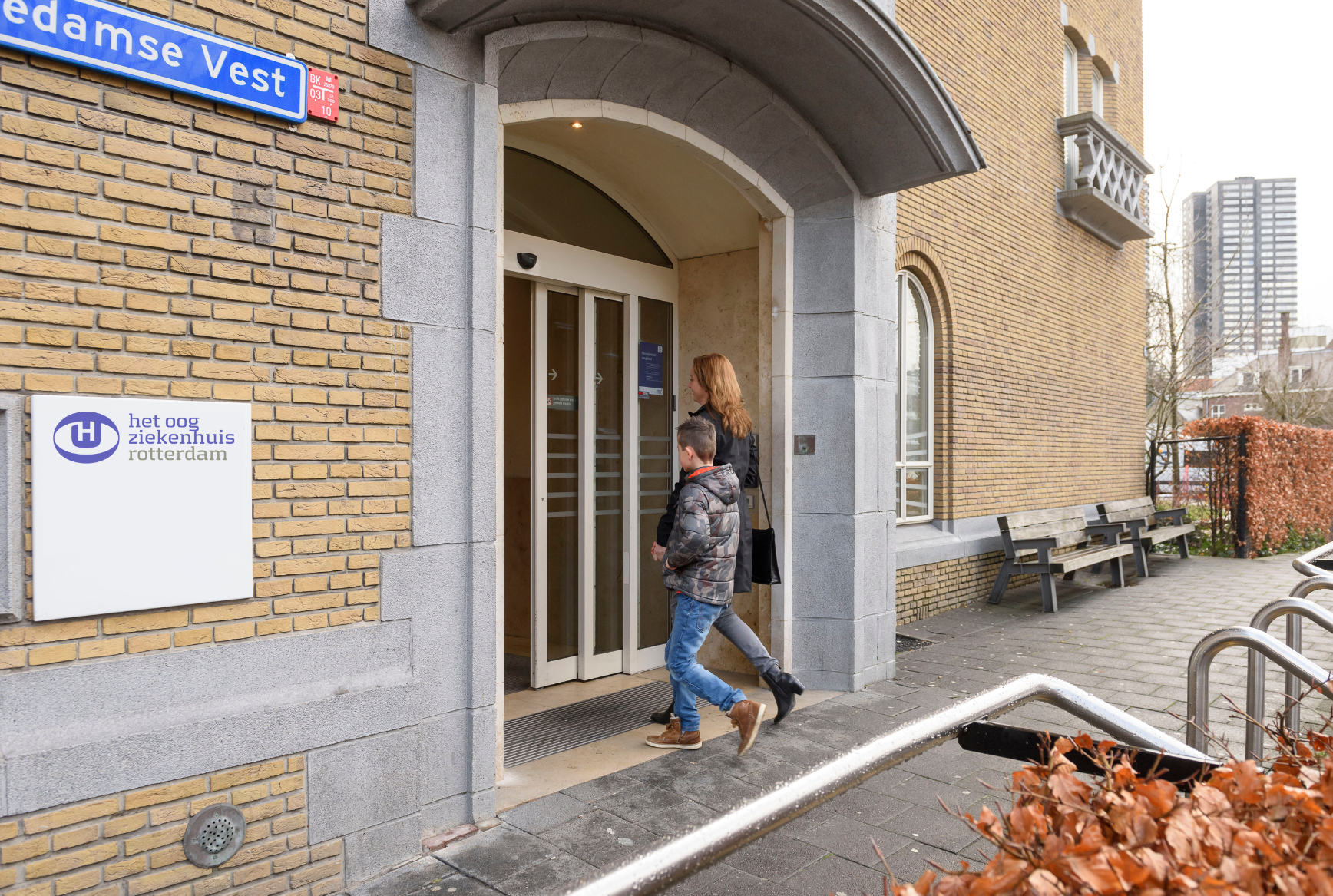 Moeder en kind lopen Het Oogziekenhuis Rotterdam binnen