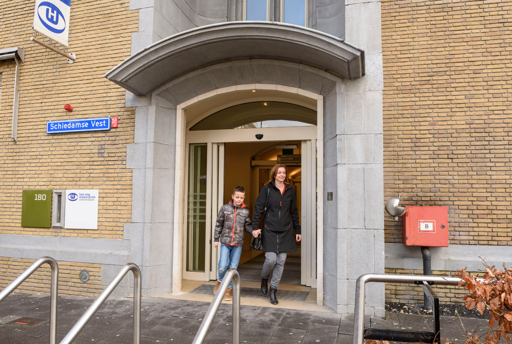 Moeder en kind lopen Het Oogziekenhuis Rotterdam uit