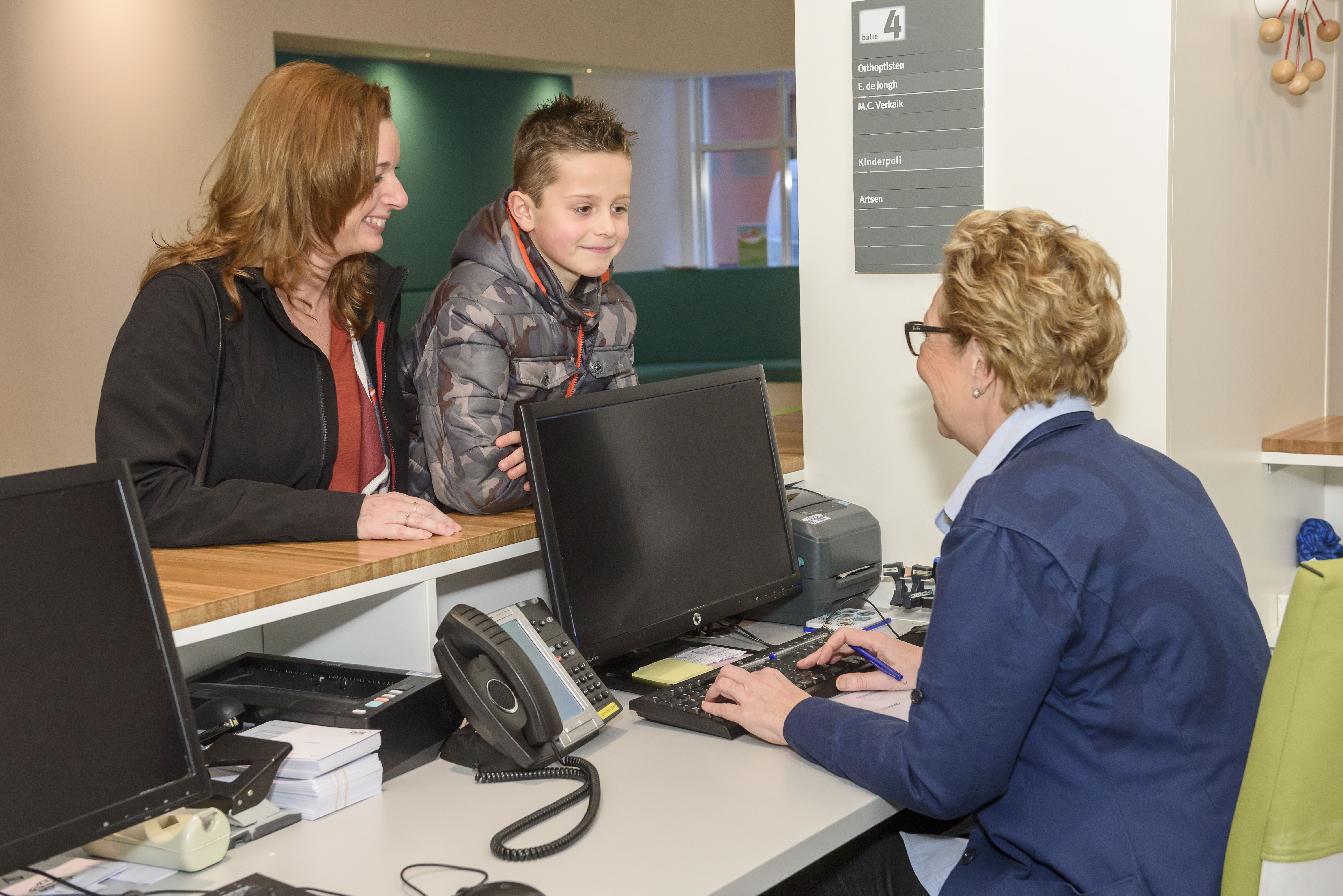 Moeder en kind aan de balie bij het KinderOOGcentrum